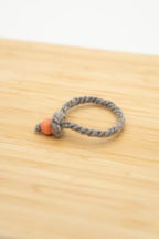 Light gray wool bracelet made from Eddie the Shetland ram on a wooden background