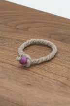 Natural gray wool bracelet made from Gustave the Shetland ram on a wooden background 