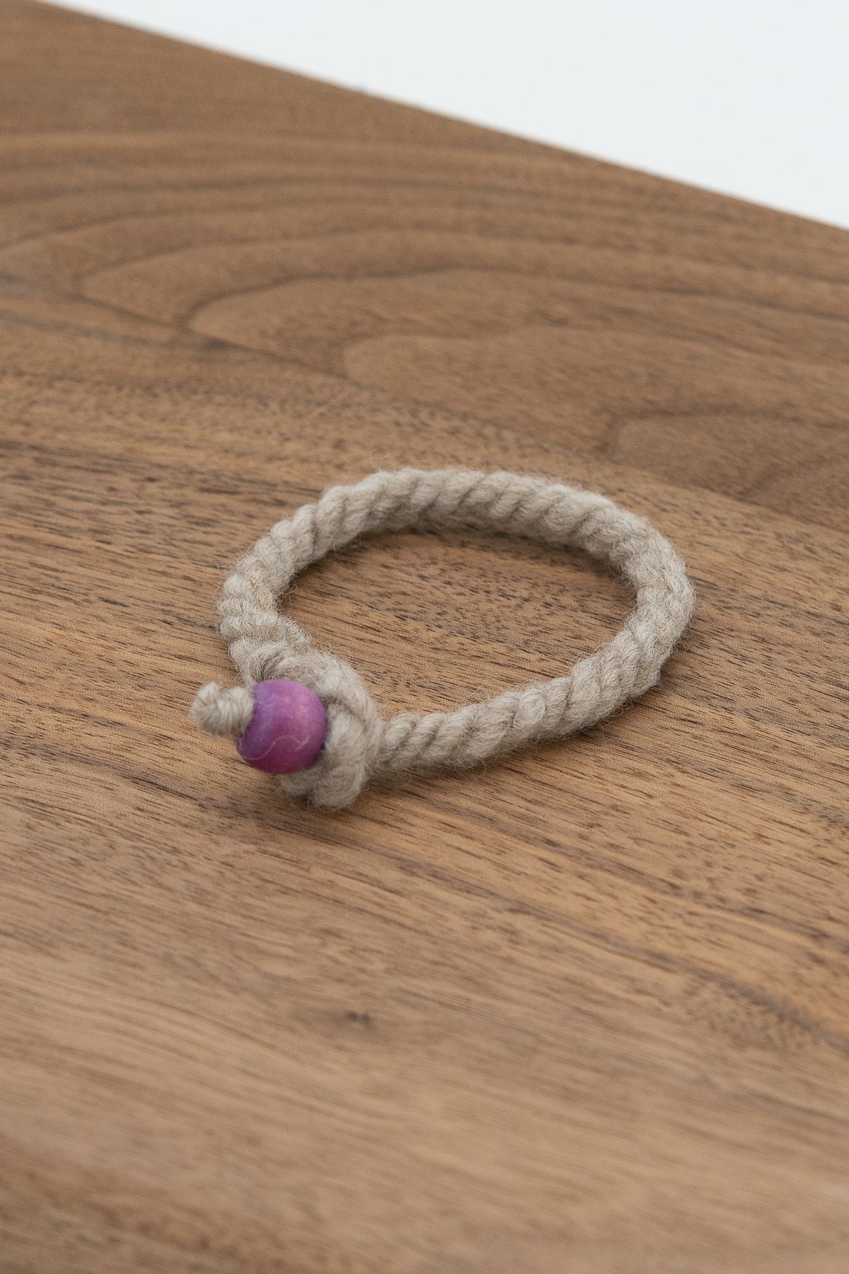 Natural gray wool bracelet made from Gustave the Shetland ram on a wooden background 