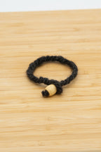 Black antural wool bracelet handmade from Norma the Shetland sheep on a wooden background