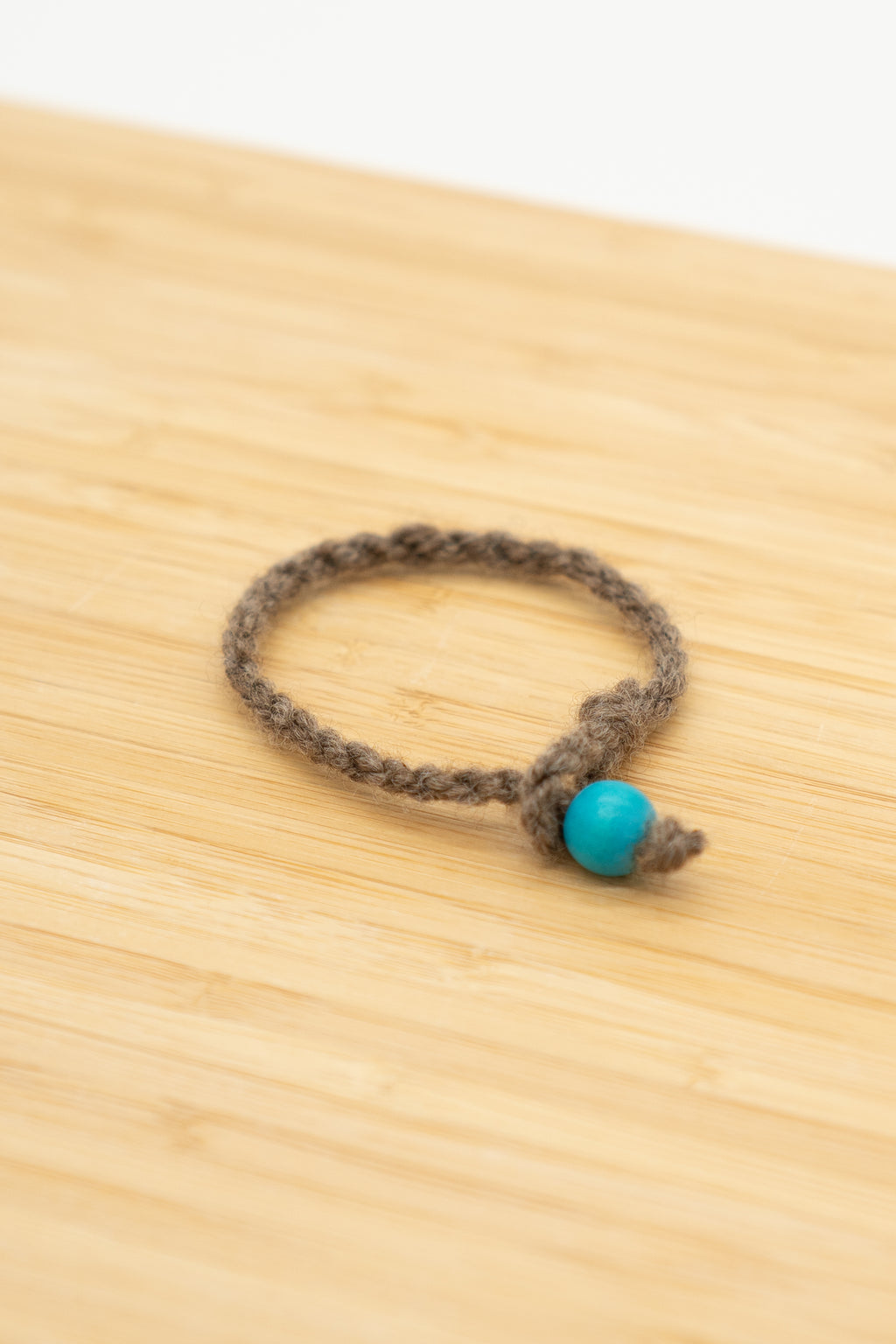 Brown wool bracelet made from Paula the Shetland sheep on a wooden background
