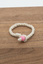 White wool bracelet handmade from Valkia the Finnsheep on a wooden background 